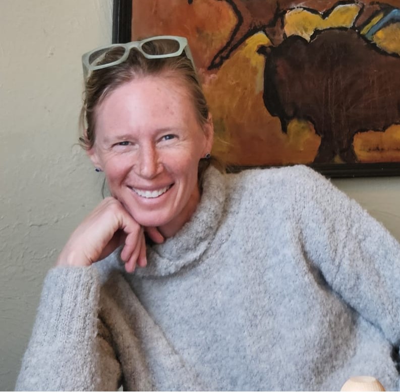 Libby Foster, smiling in front of a painting.